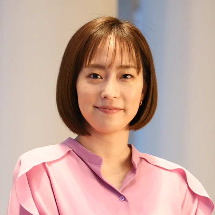 石川佳純さんがピンクのシャツを着て微笑んでいる写真